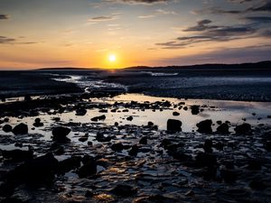 Preview wallpaper beach, sunset, water, stones, sand, sea, dusk