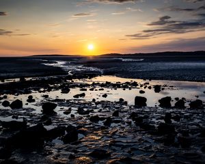 Preview wallpaper beach, sunset, water, stones, sand, sea, dusk