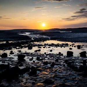 Preview wallpaper beach, sunset, water, stones, sand, sea, dusk