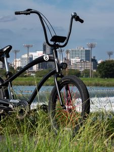 Preview wallpaper bicycle, grass, buildings, blur