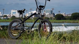 Preview wallpaper bicycle, grass, buildings, blur