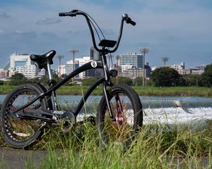 Preview wallpaper bicycle, grass, buildings, blur