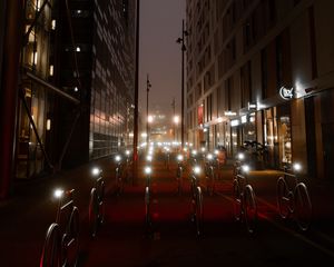 Preview wallpaper bicycles, constructions, road, lights, buildings, night