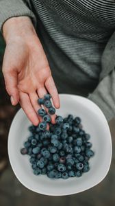 Preview wallpaper blueberries, berries, hand, bowl