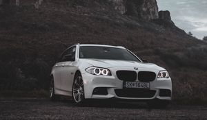 Preview wallpaper bmw, car, white, front view, rock, nature