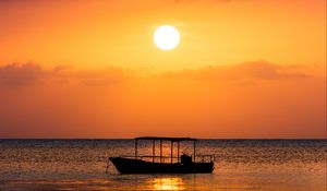 Preview wallpaper boat, sea, sunset, sun, water, dusk