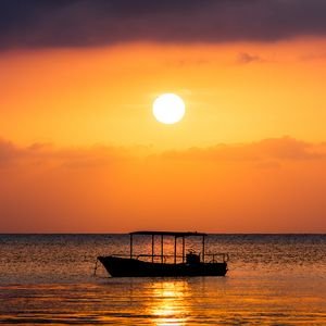 Preview wallpaper boat, sea, sunset, sun, water, dusk