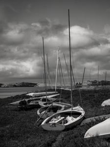 Preview wallpaper boats, grass, sea, clouds, black and white