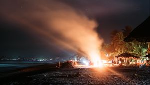 Preview wallpaper bonfire, beach, night, starry sky, smoke, palm trees, bright