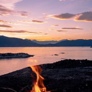 Preview wallpaper bonfire, fire, camping, sea, mountains, sunset