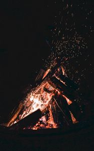 Preview wallpaper bonfire, sparks, fire, firewood, dark, darkness