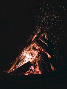 Preview wallpaper bonfire, sparks, fire, firewood, dark, darkness