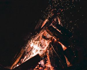 Preview wallpaper bonfire, sparks, fire, firewood, dark, darkness