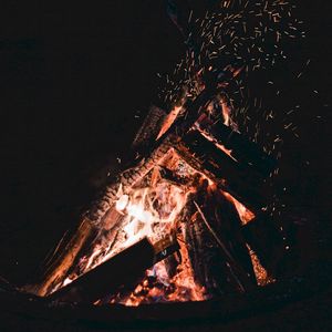 Preview wallpaper bonfire, sparks, fire, firewood, dark, darkness