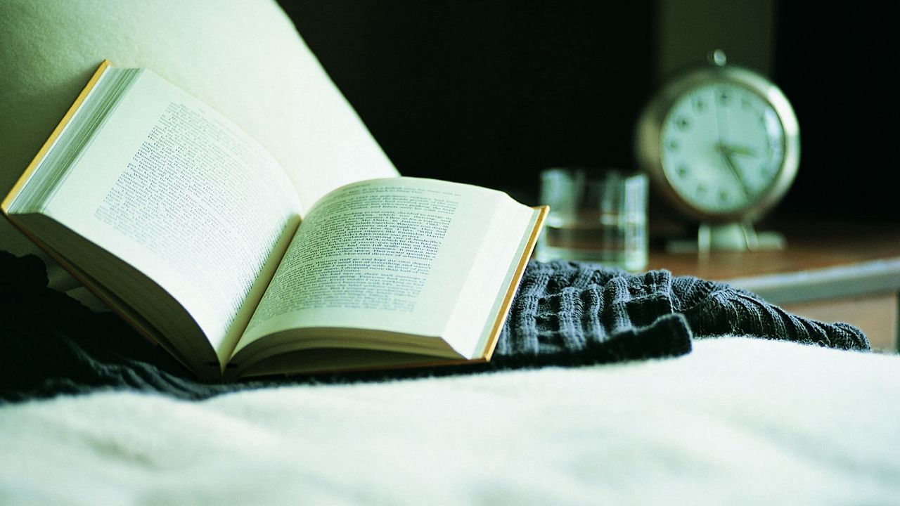 Wallpaper book, bed, alarm clock, reading