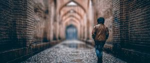 Preview wallpaper boy, street, rain, walls, arches, stone