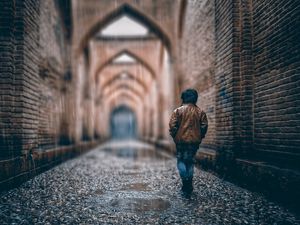 Preview wallpaper boy, street, rain, walls, arches, stone