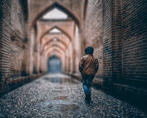 Preview wallpaper boy, street, rain, walls, arches, stone