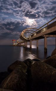 Preview wallpaper bridge, arches, pilings, sea, rocks, twilight