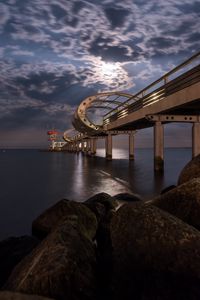 Preview wallpaper bridge, arches, pilings, sea, rocks, twilight