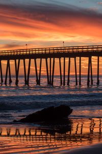 Preview wallpaper bridge, construction, sea, stones, sunset