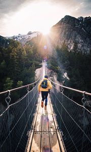 Preview wallpaper bridge, man, mountains, sunlight, switzerland