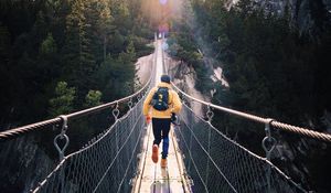 Preview wallpaper bridge, man, mountains, sunlight, switzerland