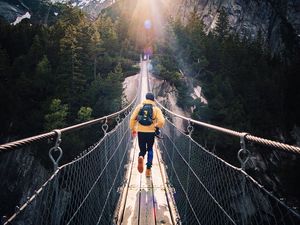 Preview wallpaper bridge, man, mountains, sunlight, switzerland