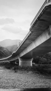 Preview wallpaper bridge, pilings, river, bw, mountains