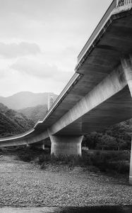 Preview wallpaper bridge, pilings, river, bw, mountains