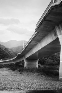 Preview wallpaper bridge, pilings, river, bw, mountains