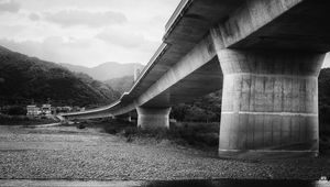 Preview wallpaper bridge, pilings, river, bw, mountains