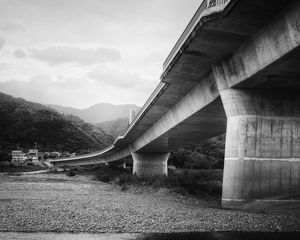 Preview wallpaper bridge, pilings, river, bw, mountains