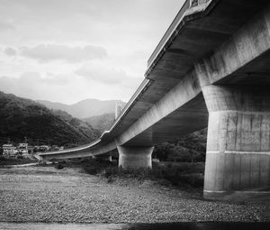 Preview wallpaper bridge, pilings, river, bw, mountains