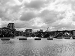 Preview wallpaper bridge, river, clouds, buildings, black and white