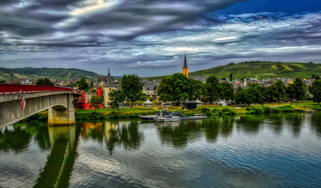 1024x600 Wallpaper bridge, river, motor ships, buildings, trees, clouds, landscape