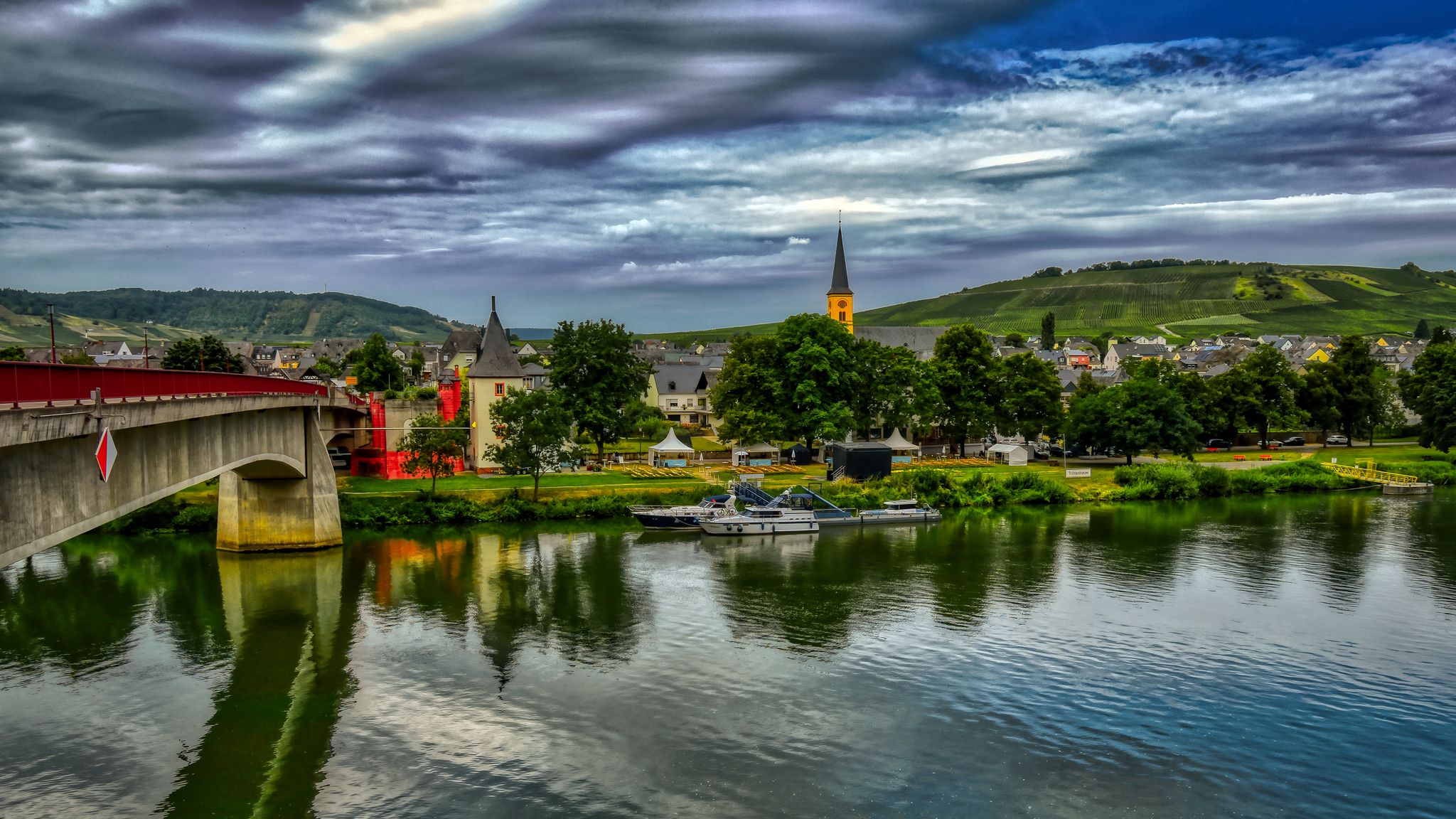 2048x1152 Wallpaper bridge, river, motor ships, buildings, trees, clouds, landscape