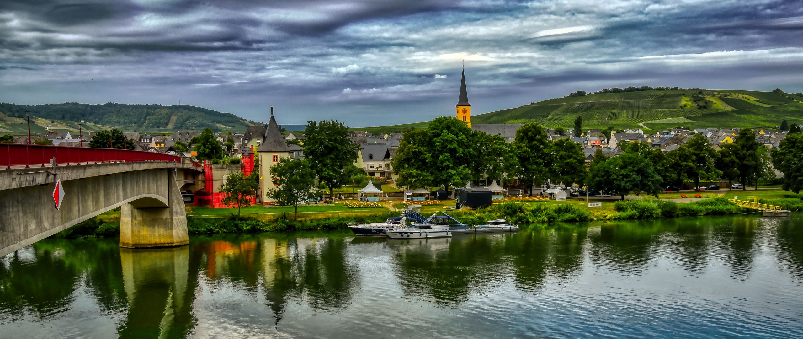 2560x1080 Wallpaper bridge, river, motor ships, buildings, trees, clouds, landscape