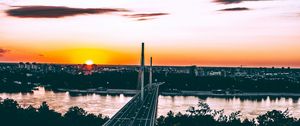 Preview wallpaper bridge, road, city, sunset, sun, trees
