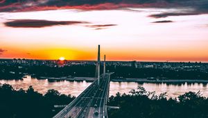 Preview wallpaper bridge, road, city, sunset, sun, trees