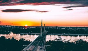 Preview wallpaper bridge, road, city, sunset, sun, trees