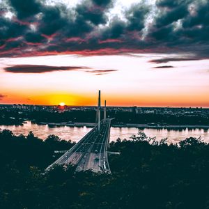 Preview wallpaper bridge, road, city, sunset, sun, trees