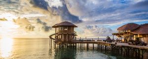 Preview wallpaper bridge, sea, buildings, sun, sunset