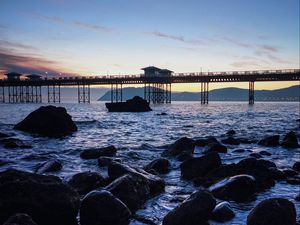 Preview wallpaper bridge, sea, rocks, twilight