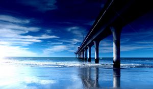 Preview wallpaper bridge, support, pier, columns, coast, beach, waves, dawn, blue