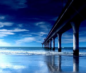 Preview wallpaper bridge, support, pier, columns, coast, beach, waves, dawn, blue