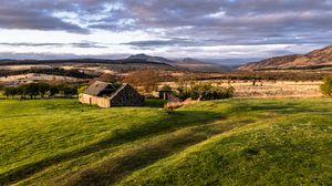 Preview wallpaper building, hills, grass, nature, landscape