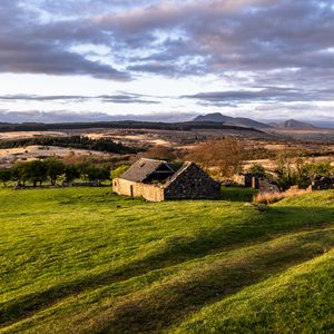 Preview wallpaper building, hills, grass, nature, landscape