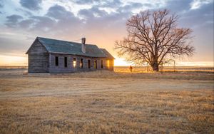 Preview wallpaper building, man, tree, field, sunset, nature