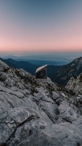 Preview wallpaper building, mountains, peaks, distance, sunset, stone